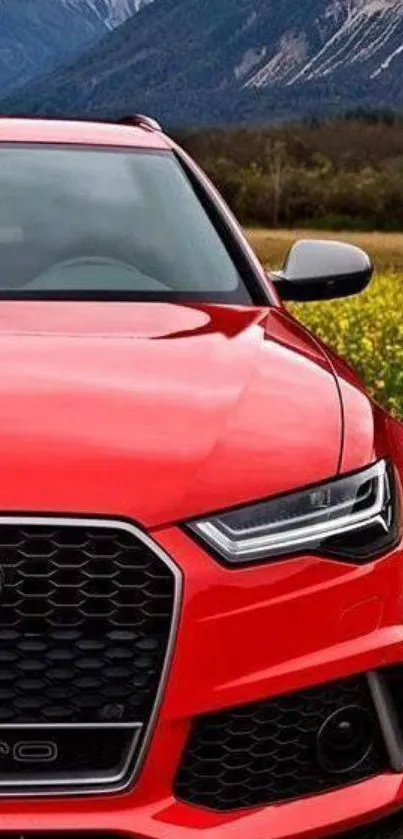 Sleek red car with mountain backdrop in stunning wallpaper.