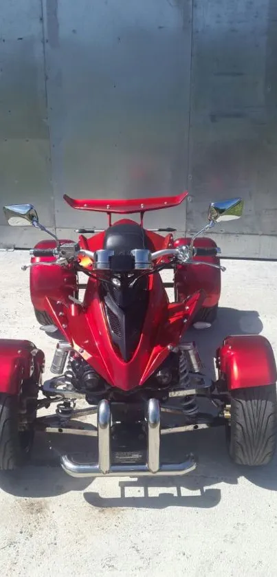 Sleek red quad bike against a metallic background, capturing vibrant energy.