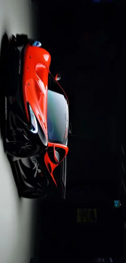 Red sports car displayed in a dark room.