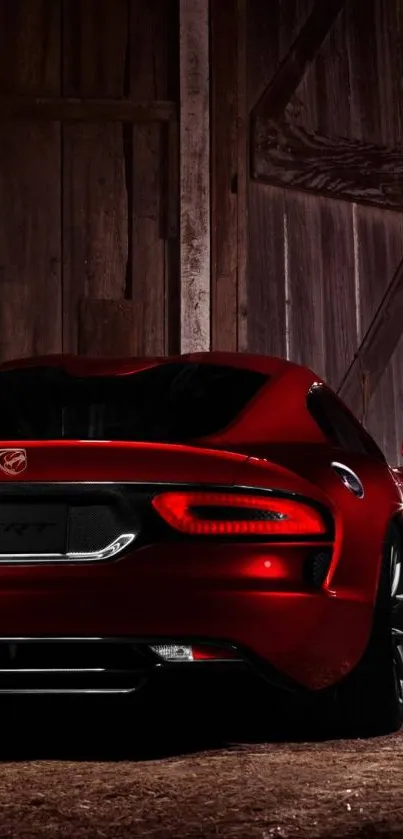 Sleek red sports car near a rustic barn.