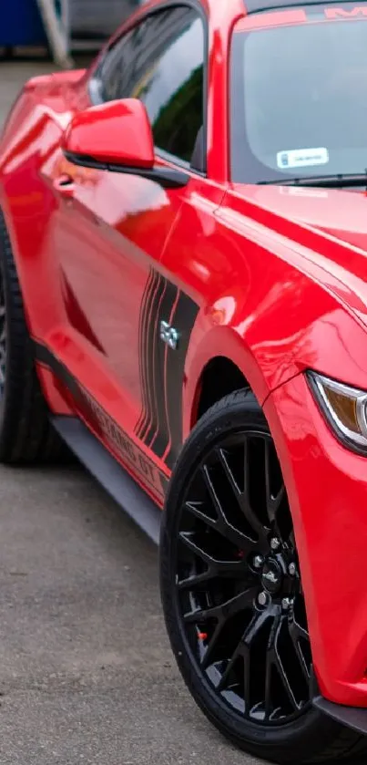 Vibrant red sports car with black rims and sleek design on pavement.