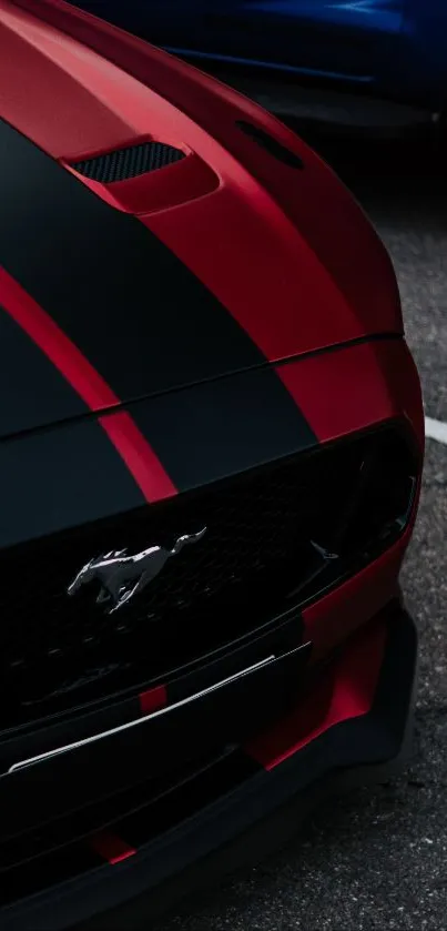 Sleek red sports car with black stripes on asphalt background.