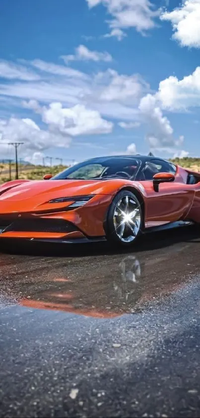 Red sports car on wet road reflecting sky.