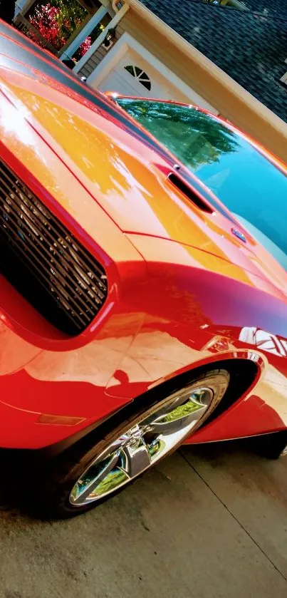 Vivid red sports car with chrome wheels parked in driveway.