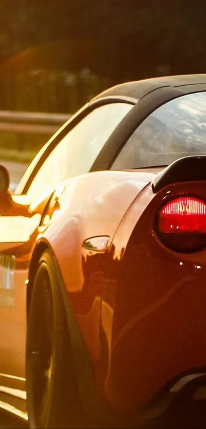 Vibrant red sports car driving at sunset.