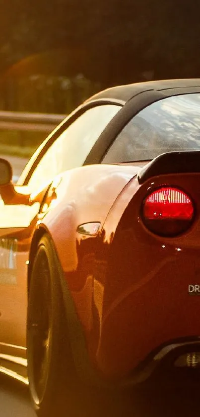 Red sports car speeding on a highway at sunset.