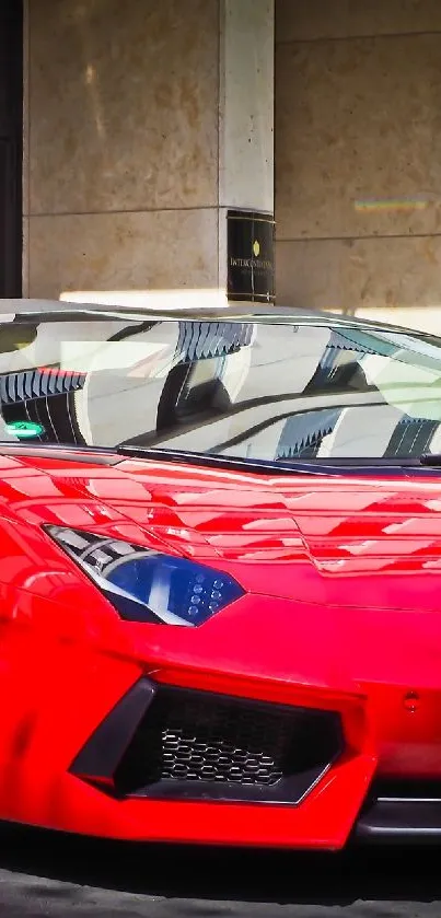 Red sports car parked outside modern building.