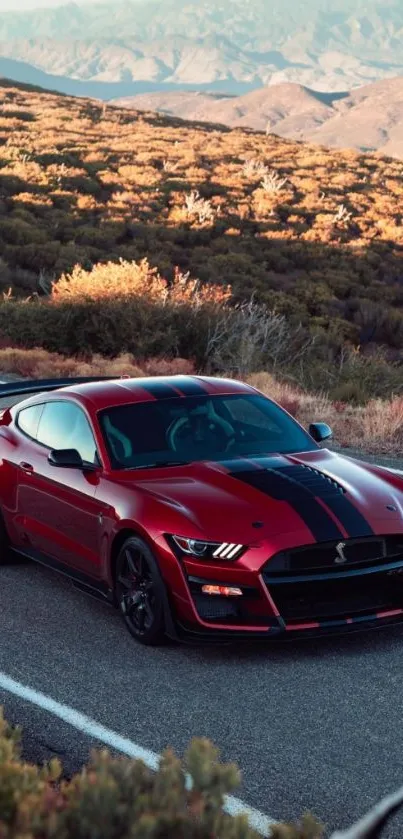 Red sports car driving on a scenic mountain road.