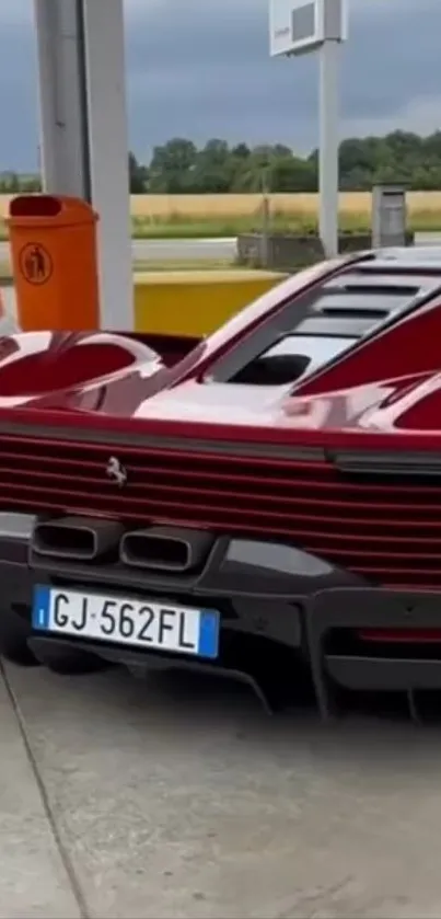 Sleek red supercar parked at a gas station.