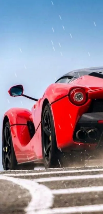 Sleek red supercar on a track with a clear blue sky backdrop.