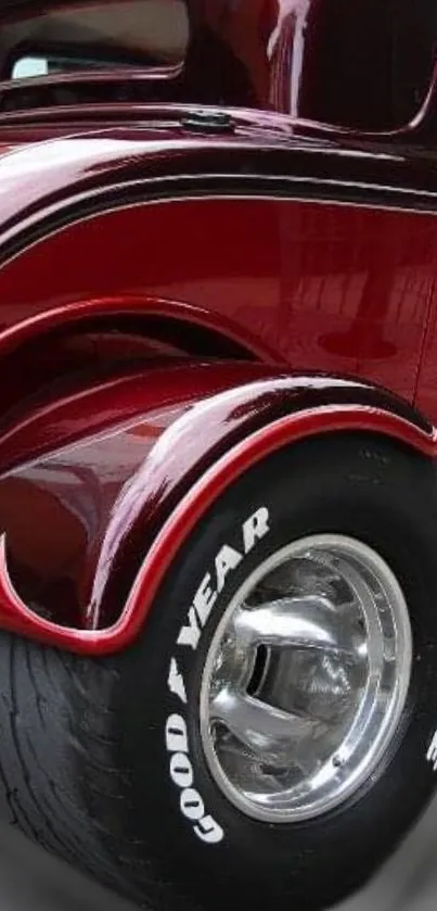 Glossy red vintage car with detailed wheels and sleek design.