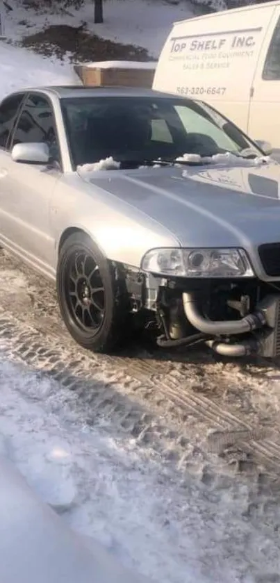 Sleek silver car parked in a snowy setting.