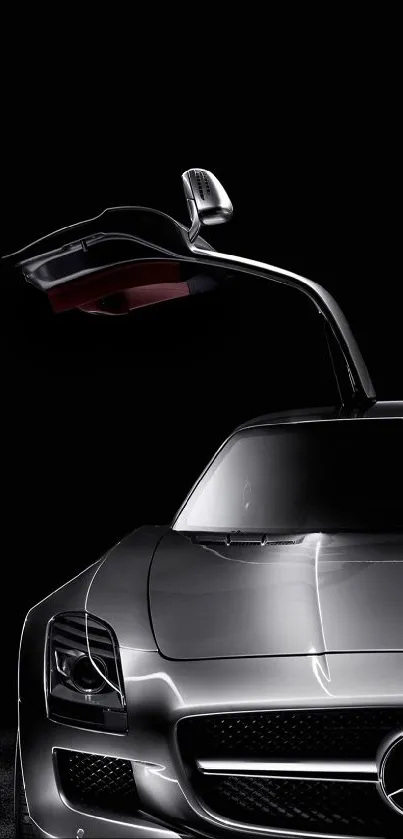 Sleek silver car with gullwing doors on a dark background.