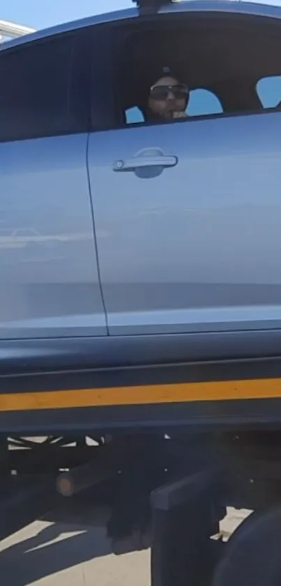 Sleek silver car with black accents on a highway.