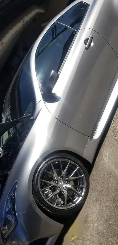 Sleek silver car parked outside garage in sunlight.