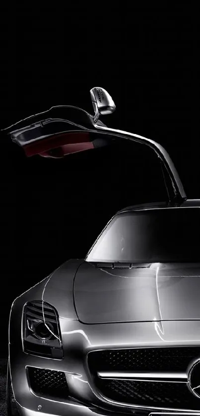 Sleek silver sports car with gull-wing doors on a black background.