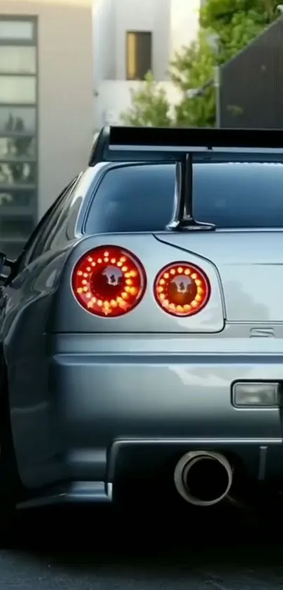 Sleek silver sports car with stylish tail lights in urban setting.