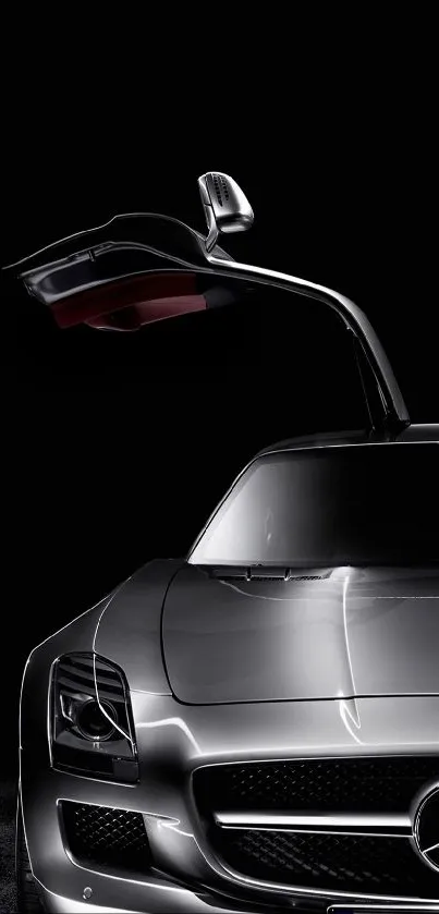 Silver sports car with gull-wing doors against a black background.