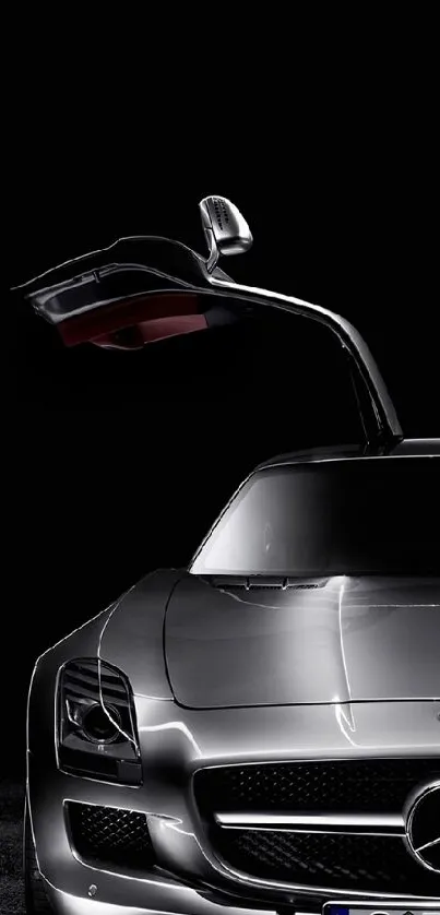 Sleek silver sports car with gullwing doors on black background.