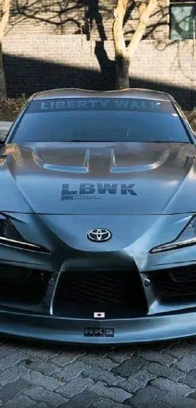 Sleek silver sports car in outdoor setting.