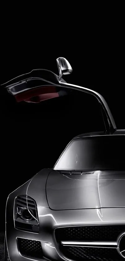 Sleek silver sports car with one door open against a dark backdrop.