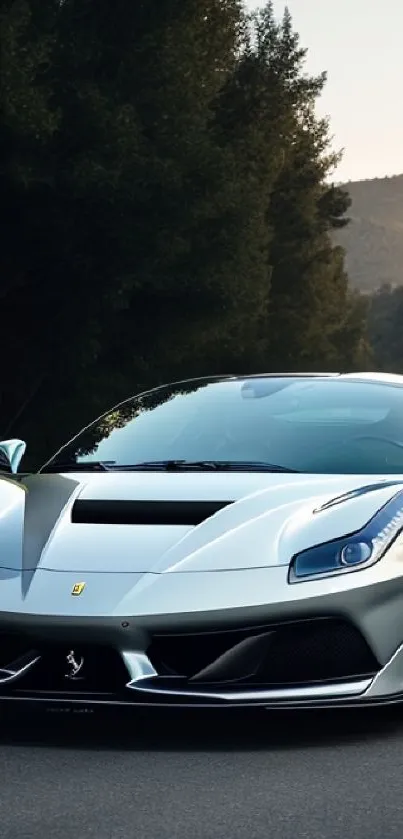 Sleek silver sports car on a scenic road at sunset.