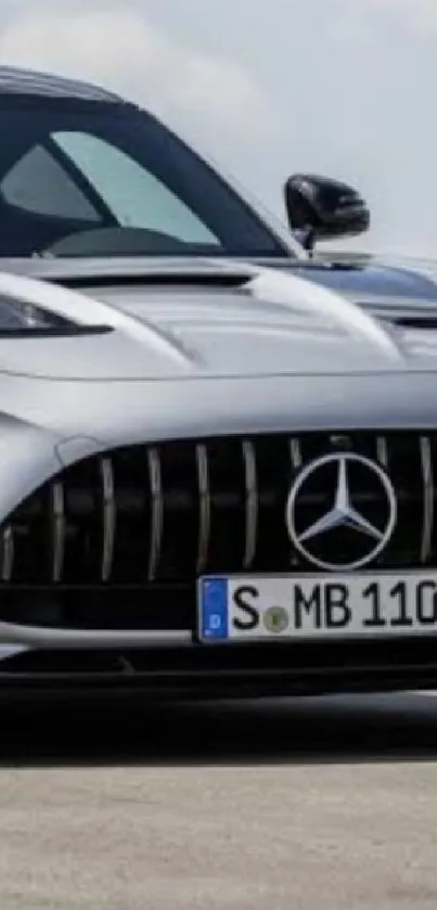 Sleek silver sports car on open road.