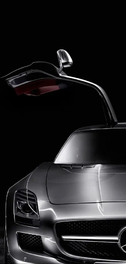 Sleek silver sports car with gullwing doors against a black background.