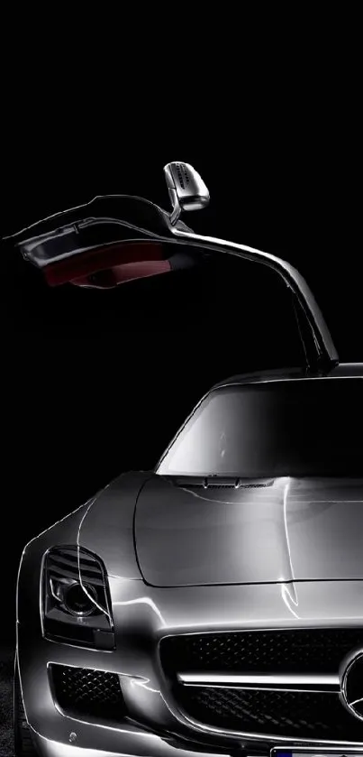 Sleek silver sports car with gullwing door on a black background.