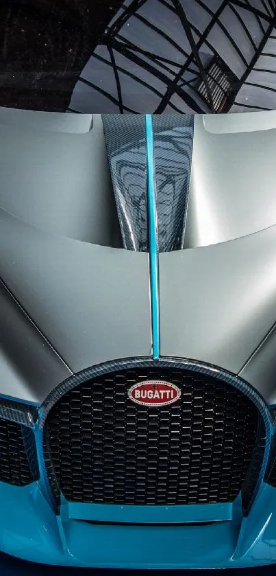 Stylish silver supercar with blue floor reflection.