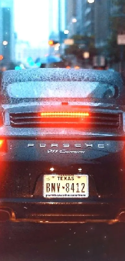 Sleek sports car on a rainy city street at night.