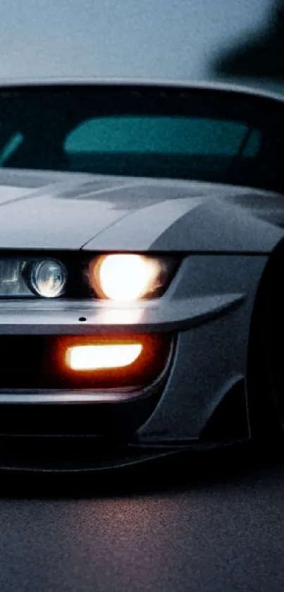 Sleek sports car driving at night with illuminated headlights.