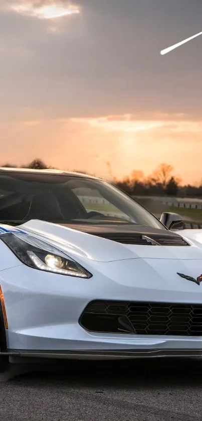 Sleek white sports car under an orange sunset sky.