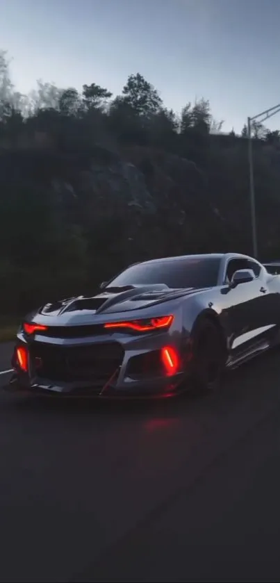 Sleek sports car driving at night on open road.