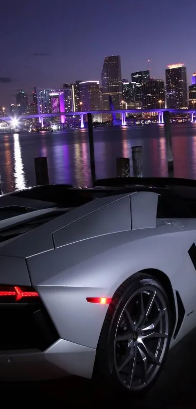 Sleek sports car parked by cityscape at night.