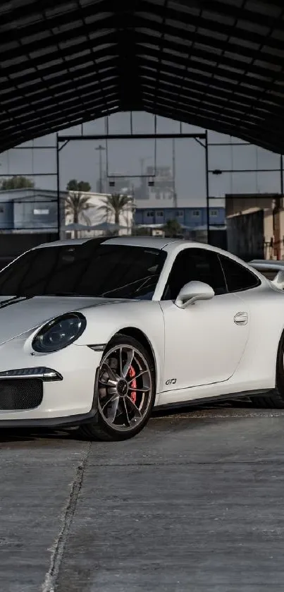 Sleek white sports car in a spacious warehouse with industrial vibes.