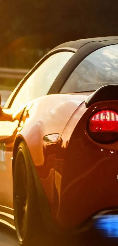 Sleek orange sports car driving on a sunny highway.