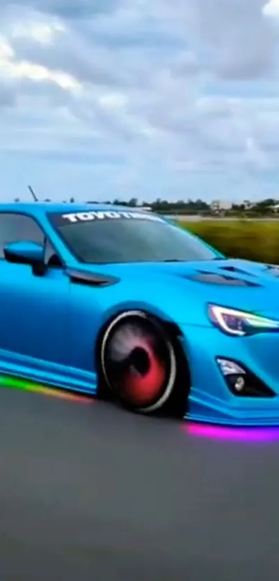 Blue sports car on road with neon lights under cloudy sky.