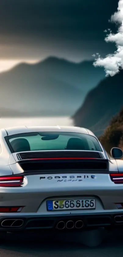 Sleek sports car on mountain road under cloudy sky.