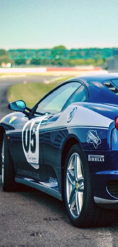 A sleek blue sports car on a race track with a vibrant background.