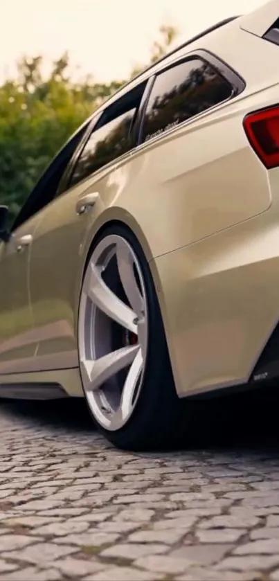 Sleek rear view of a beige sports car on a paved road.