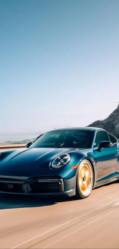 Sleek black sports car driving on a road with mountains in the background.