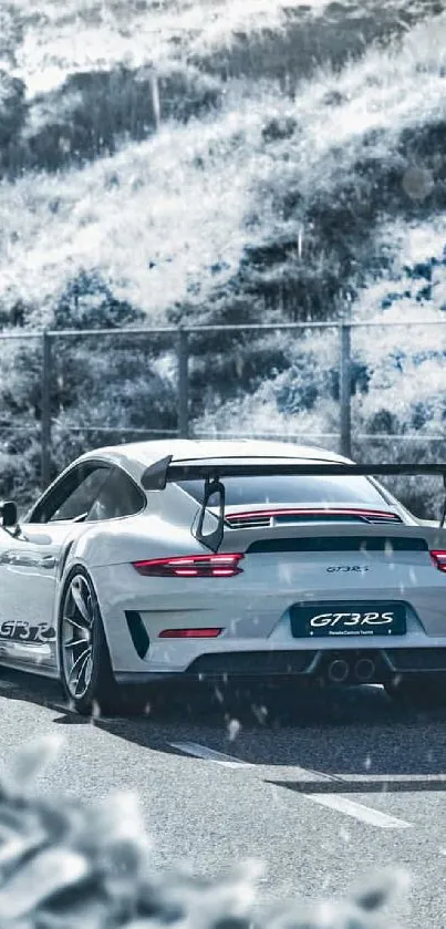 Sleek white GT3 RS sports car on a scenic road.