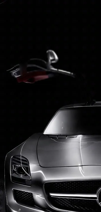 Sleek gray sports car under low light with gullwing door.