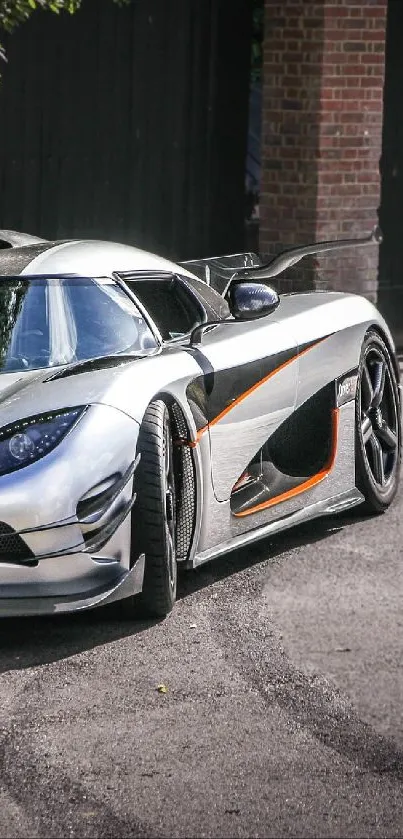 Silver sports car parked in a driveway with lush greenery around.