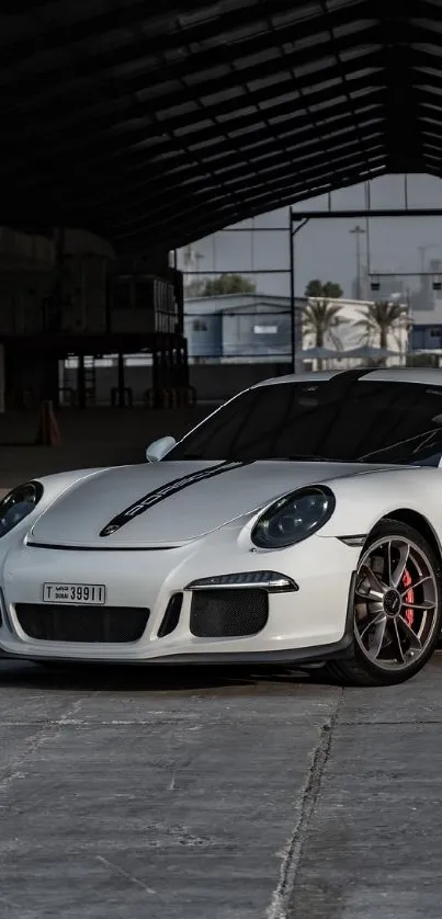 White sports car in a dimly lit warehouse setting.