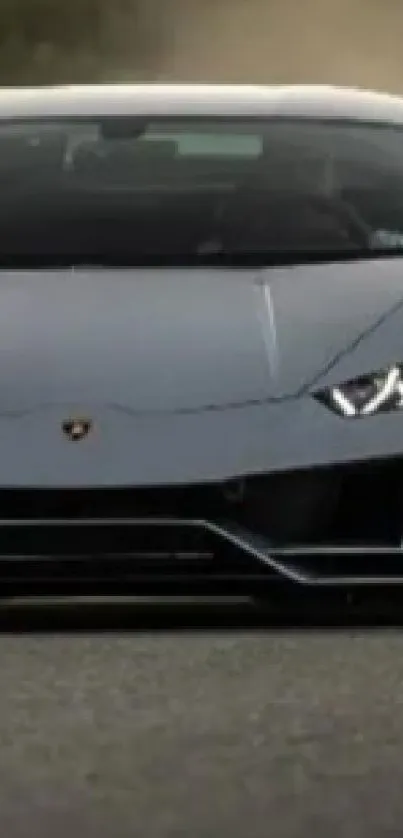 Sleek gray sports car driving fast on a dusty road.