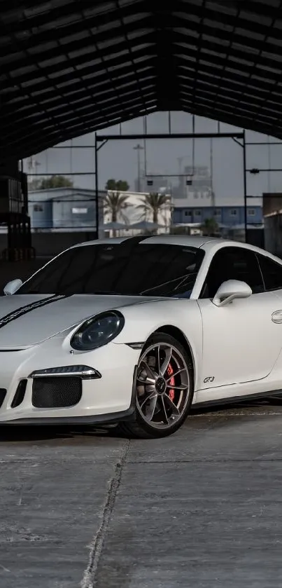 Sleek white sports car parked in a modern warehouse setting.