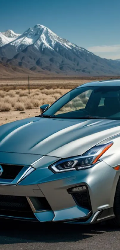 Silver sports car with mountain backdrop under blue sky.