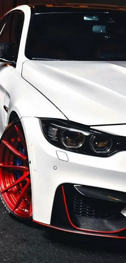 Sleek white sports car with red rims in contrast.